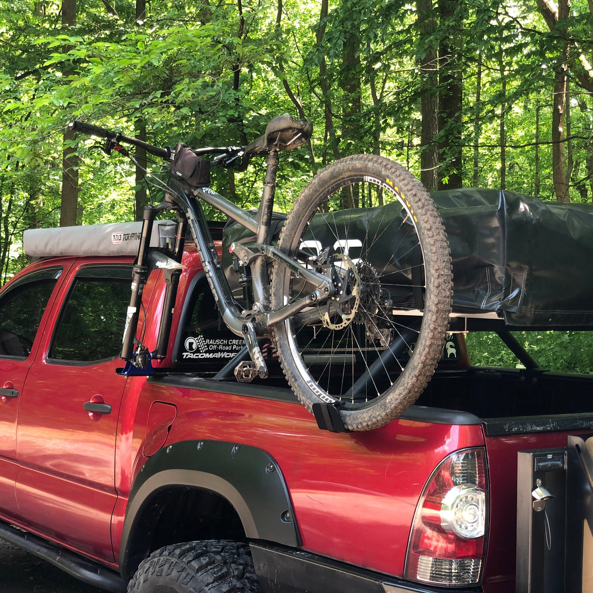 Mountain bike on SideRide mount, red Tacoma in the woods